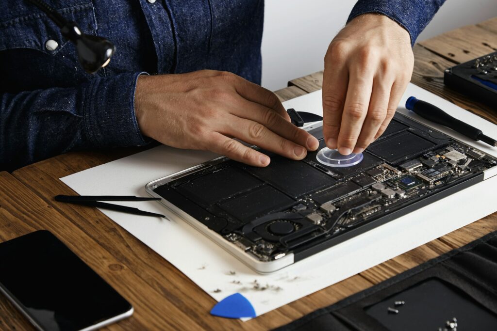 Technician performing component-level PCB repair at a workbench