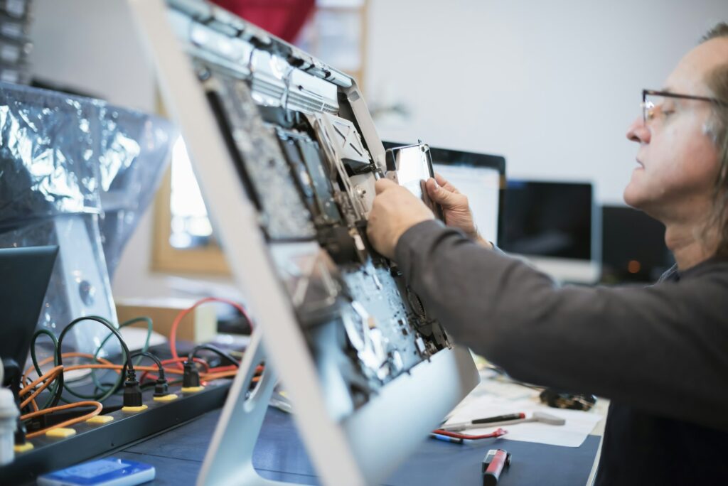 Technician disassembling a flat-panel monitor for display repair