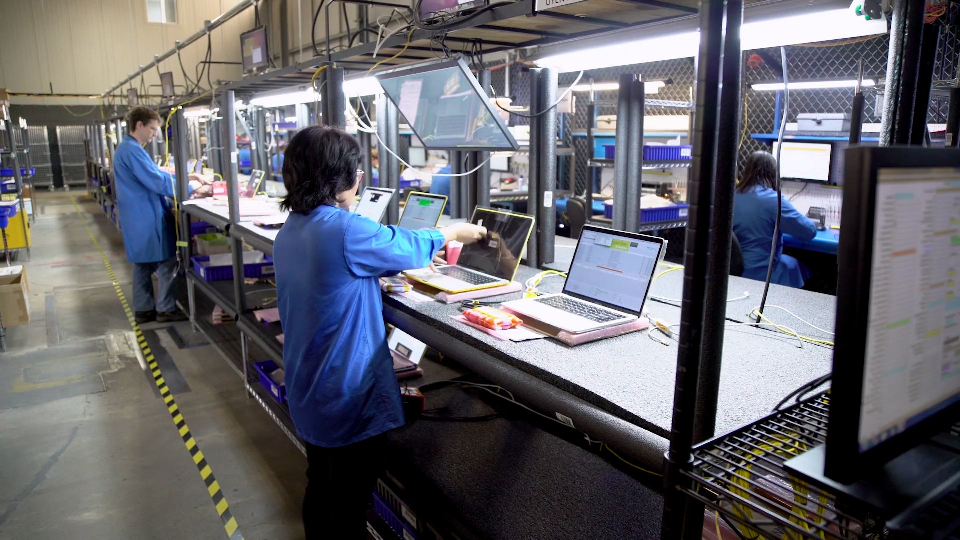 CSAT technicians diagnosing and testing laptops at the repair benches