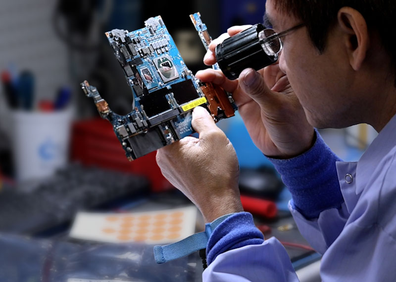 CSAT technician performing board-level repair at a bench